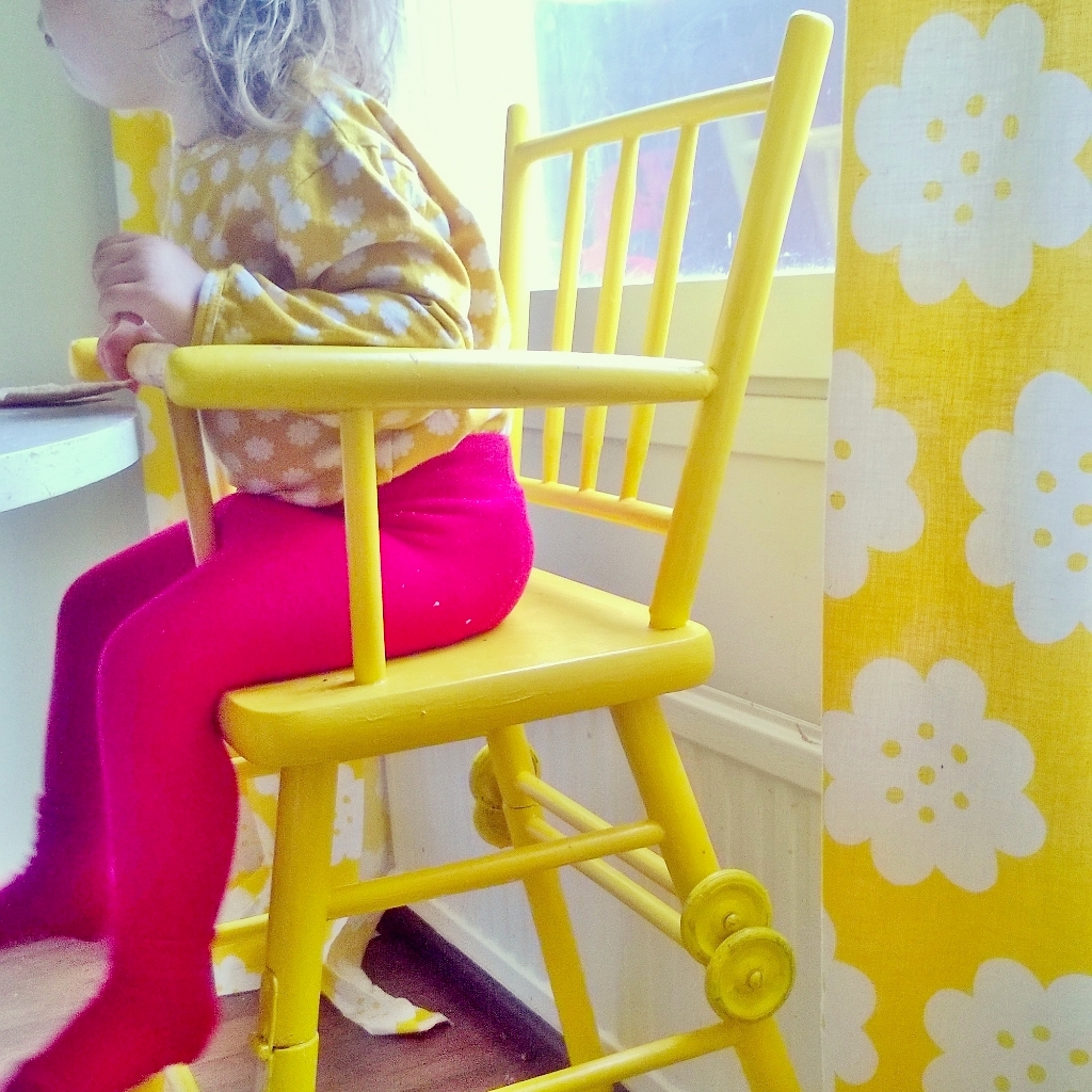 Elluyellow tytär keltaisessa retro syöttötuolissa.