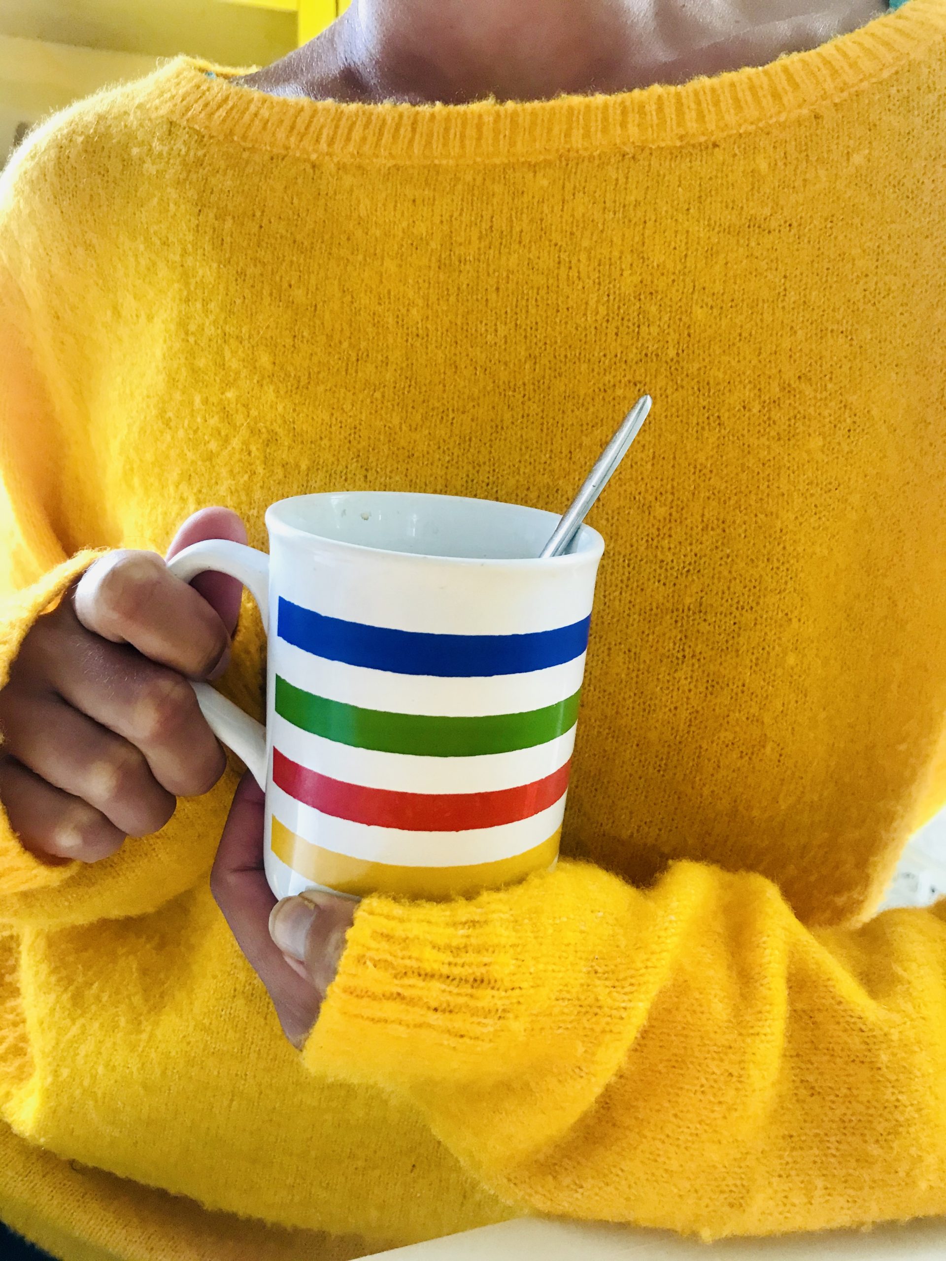 Elluyellow värikäs kahvikuppi ja keltainen villapaita