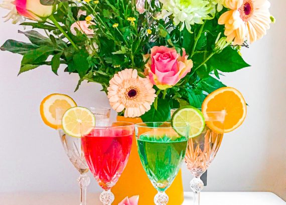 Värikkäät alkoholittomat juomat ja kukkakimppu