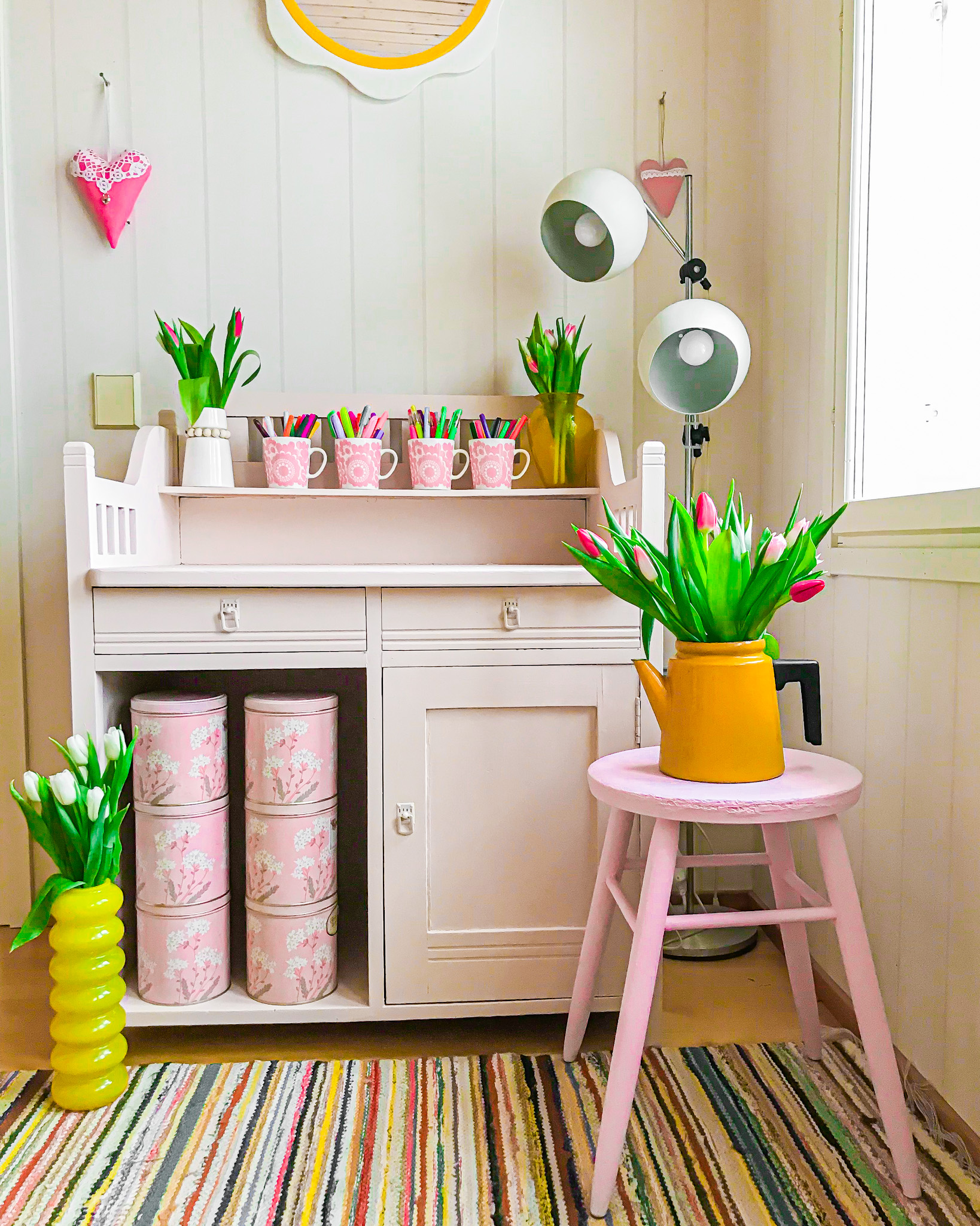 Vaaleanpunaiset maalatut huonekalut ja tulppaaneja